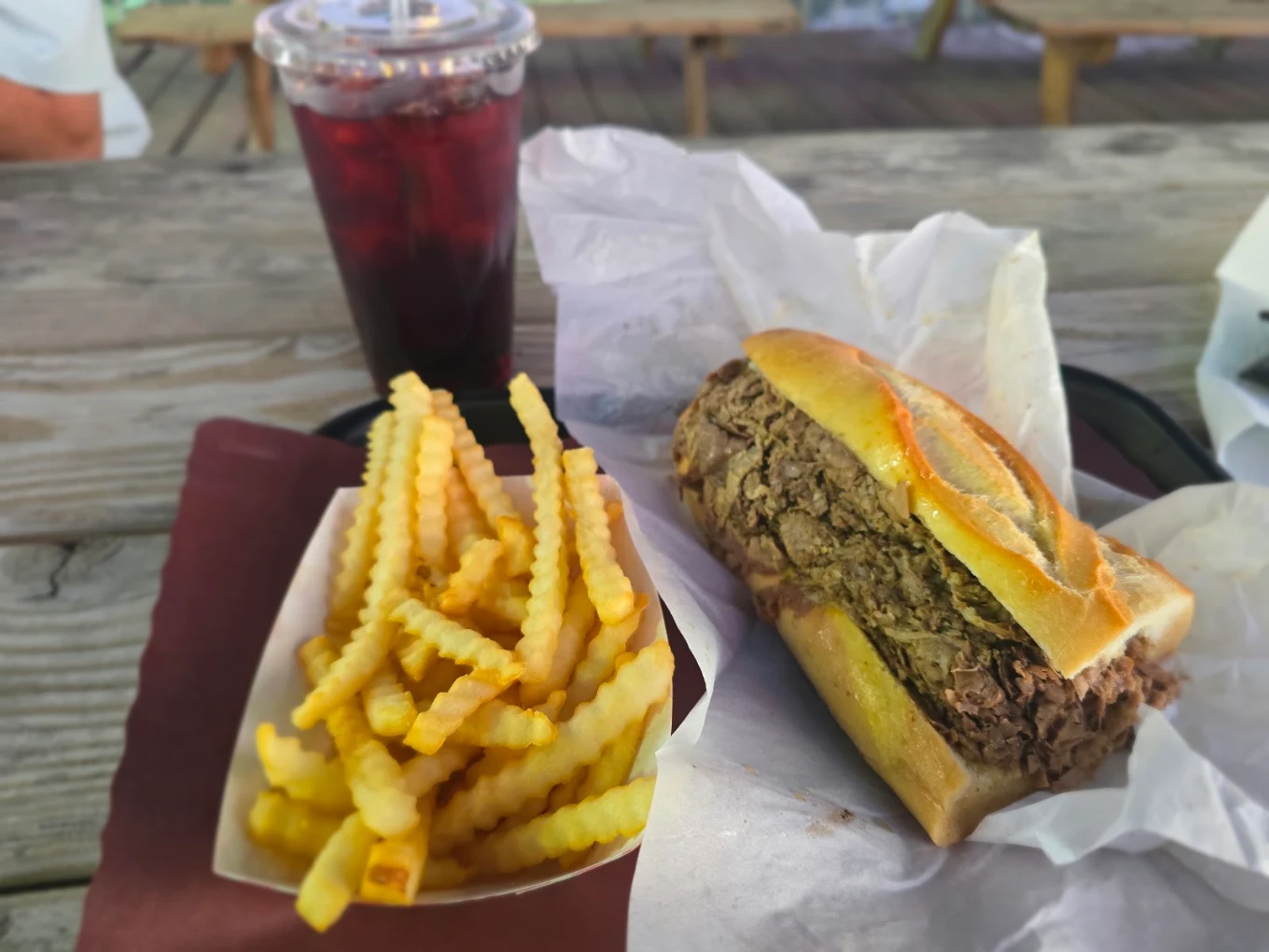 Italian beef sandwich with crinkle-cut fries and a drink