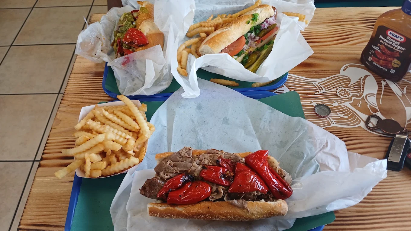 Table spread of Italian beef sandwiches with roasted peppers and fries